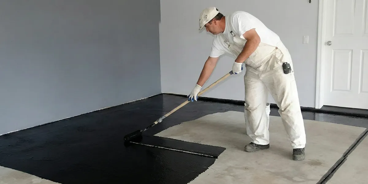 basement waterproofing professional applying waterproof coating to protect a basement floor in Mesa, AZ