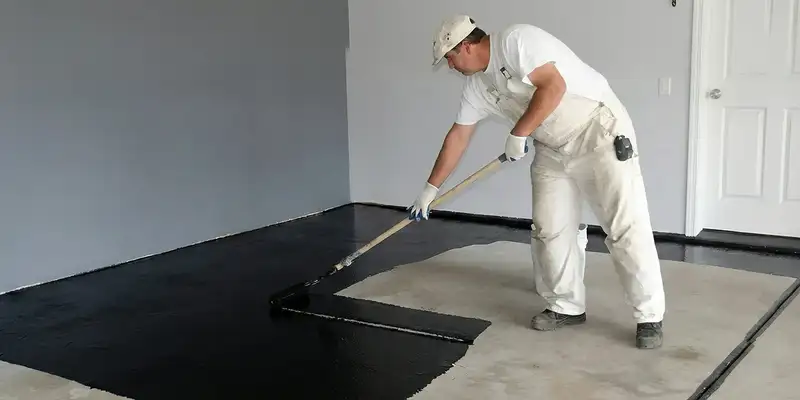basement waterproofing professional applying waterproof coating to protect a basement floor in Mesa, AZ